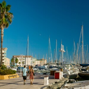 Port Frejus was created in 1982. people cycling trought the harbor along terraces of restaurants